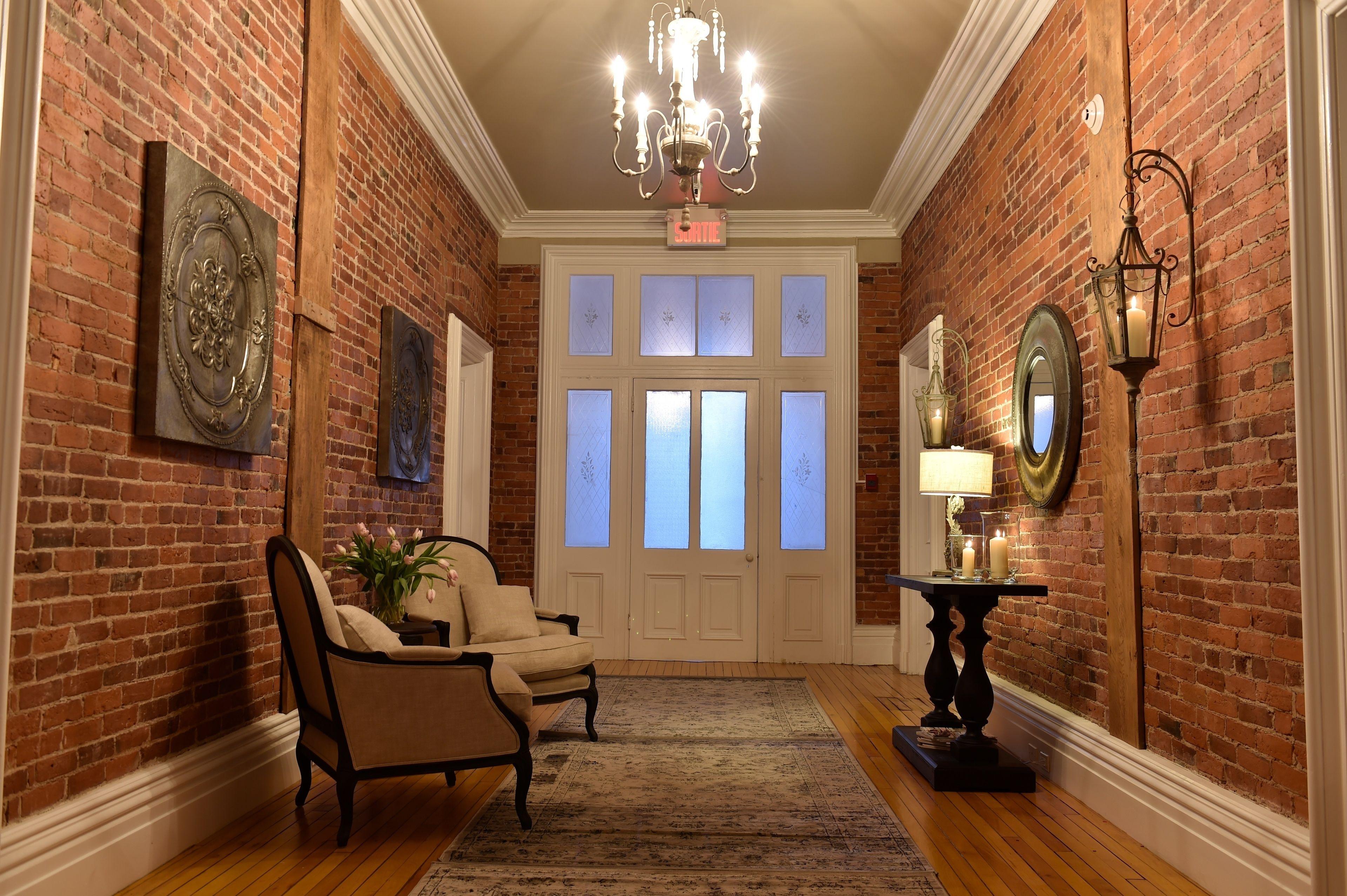 Elegant brick hallway with chandelier and vintage decor